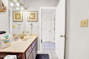 Een bad/douchecombinatie, een haardroger, handdoeken