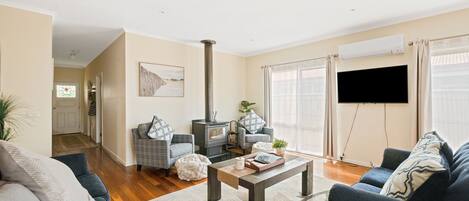 A living room with a fireplace, a sofa, a coffee table, and a TV.