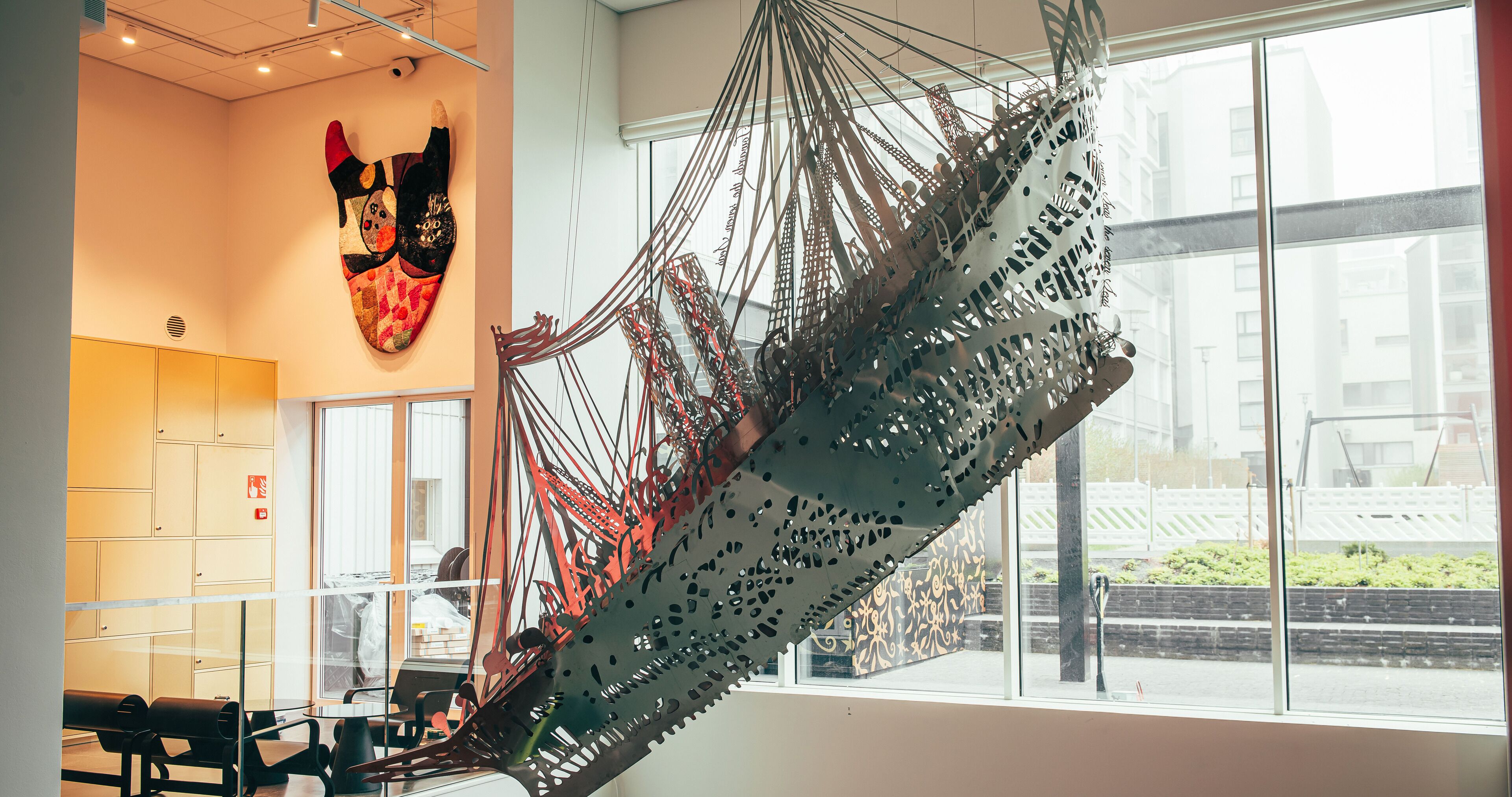 Un interior moderno con una gran escultura colgante, una zona de estar y vistas al exterior.