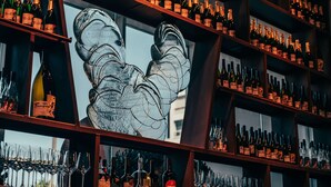 Eine Bar mit Weinregalen und Gläsern.