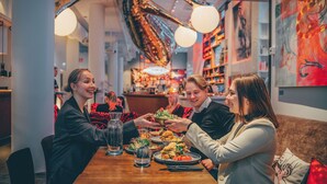 Ein Restaurantinneres mit einem Holztisch, Stühlen und verschiedenen Gerichten.