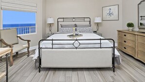 A bedroom with a bed, bedside tables, a chair, a dresser, and a ceiling fan.