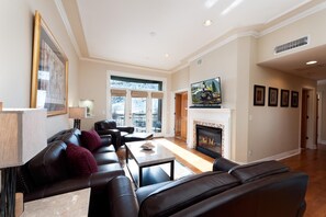 A living room with a fireplace, leather sofas, a coffee table, and a television. - Condo Located in the Heart of Downtown - Walk to Main Street & Train (Durango)