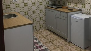 Eine kleine Küche mit Spüle, Herd und Kühlschrank.