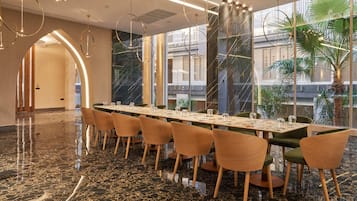 A spacious conference room with a long table, multiple chairs, and a polished marble floor.