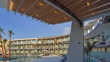 Un hôtel moderne doté d’une grande piscine, de nombreux balcons et d’un espace extérieur couvert.