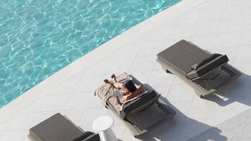 A poolside area with lounge chairs and a small table.