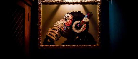 Una obra de arte enmarco que muestra a una persona con audífonos, colgada en una pared.