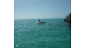 A person in a small boat on a calm sea. - Three Sisters Villa 2 (Mount Thompson)