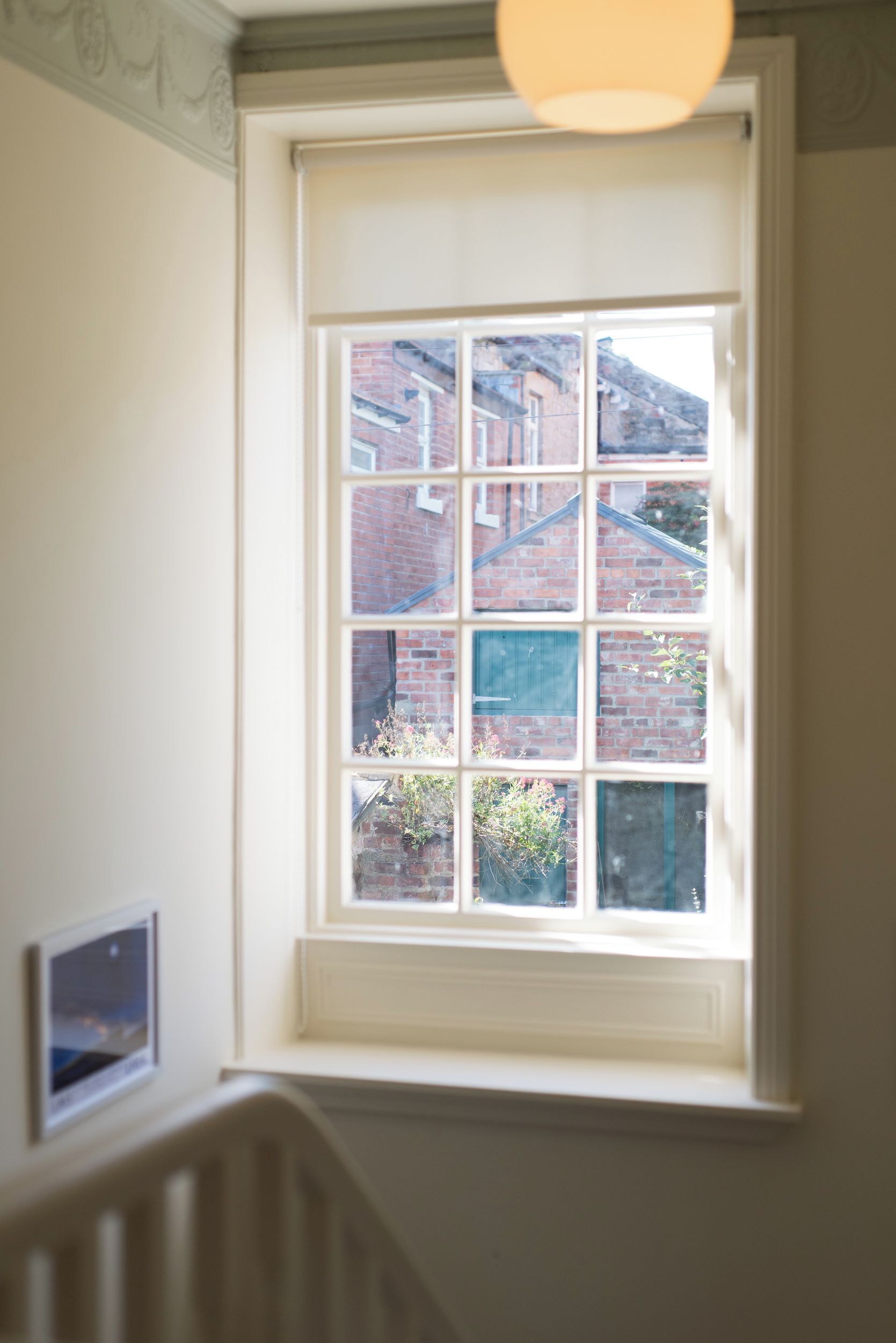 Ein Zimmer mit einem großen Fenster mit Blick auf ein Backsteingebäude.