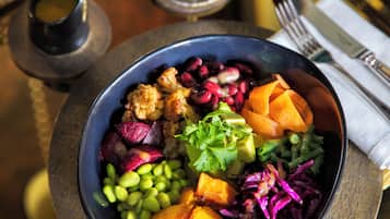 A bowl of colorful salad with various vegetables and grains.