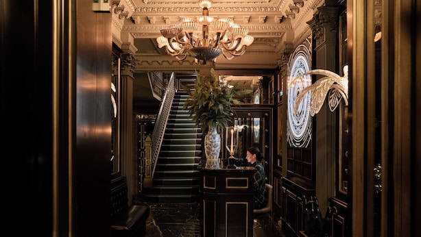 A grand hallway with a marble floor, a staircase, and a decorative chandelier. - 100 Princes Street (Edinburgh)