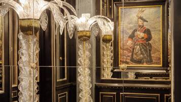 Ornate columns with intricate designs, a framed portrait, and detailed wall paneling.