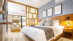 A modern hotel room with a large bed, a wooden headboard, and a view of the city. - 1BR Ocean View, Gym & Rooftop Bar! (Playa del Carmen)