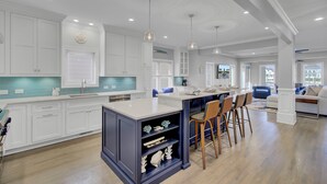 A spacious kitchen with white cabinets, a central island, and pendant lighting. - Award-Winning Resort Amenities | Yacht Harbor Court 31 (Isle of Palms)