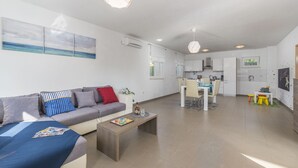 Ein modernes Wohnzimmer mit einer Couch, einem Couchtisch und Kunstwerken an der Wand.