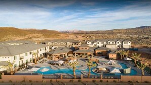 A resort with multiple buildings, a central pool area, and a mountainous backdrop. - Zion Village Poolhouse (From $299) Sleeps 24 * Spa (Hurricane)