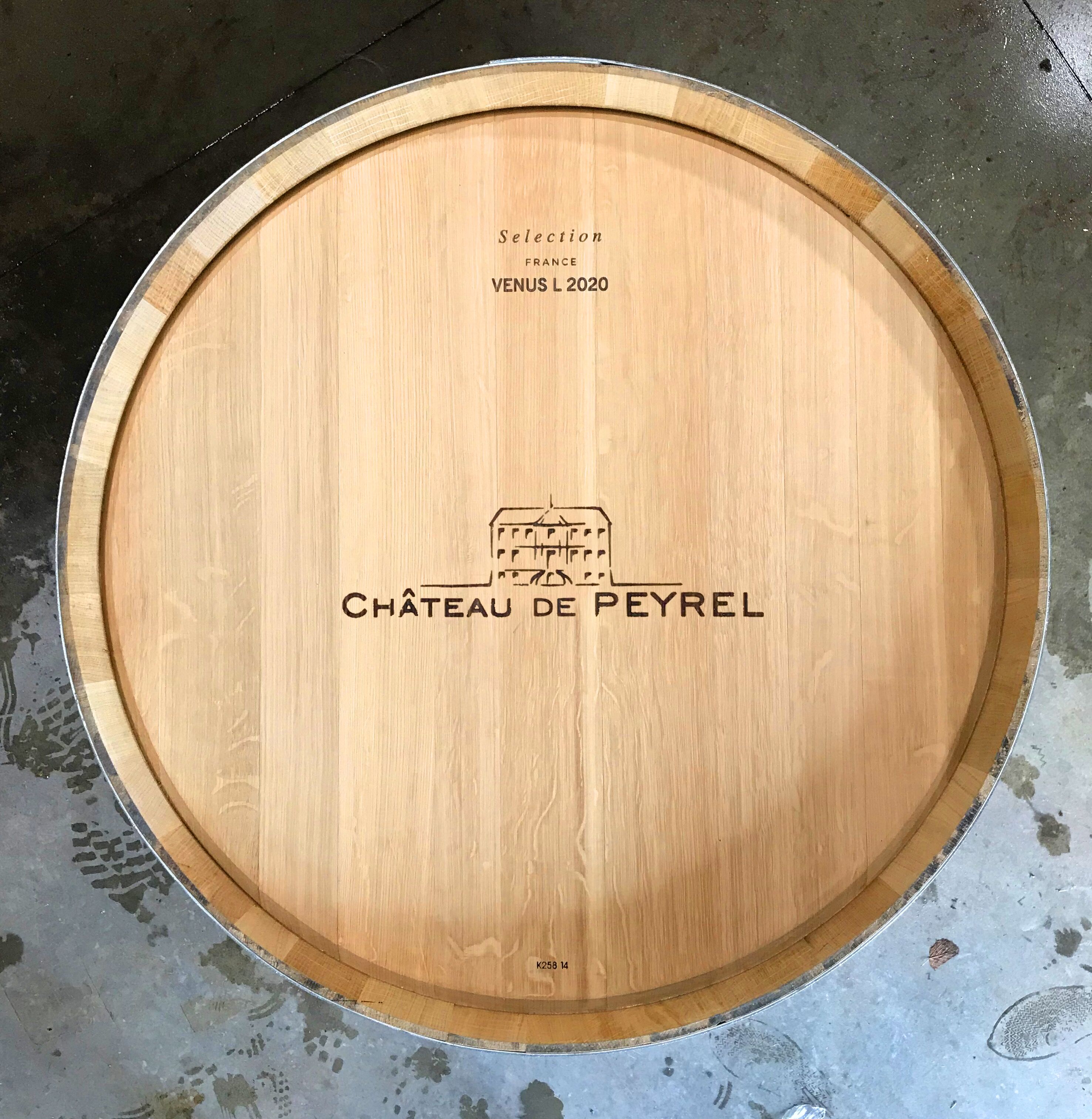 A wooden barrel with embossed text indicating 'Selection France VENUS L 2020' and 'CHÂTEAU DE PEYREL.'