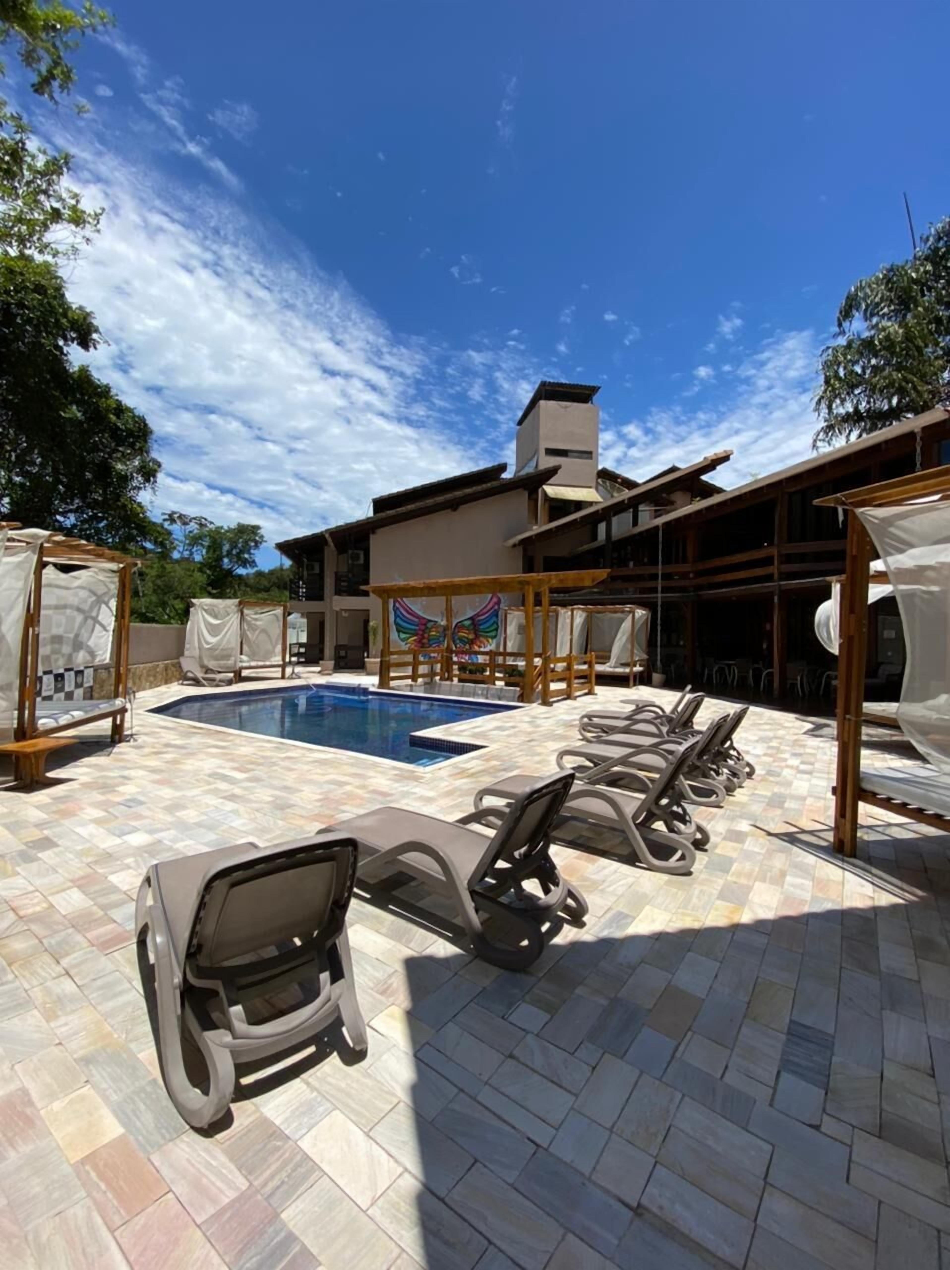Un espace piscine avec des chaises longues et un coin salon abrité.