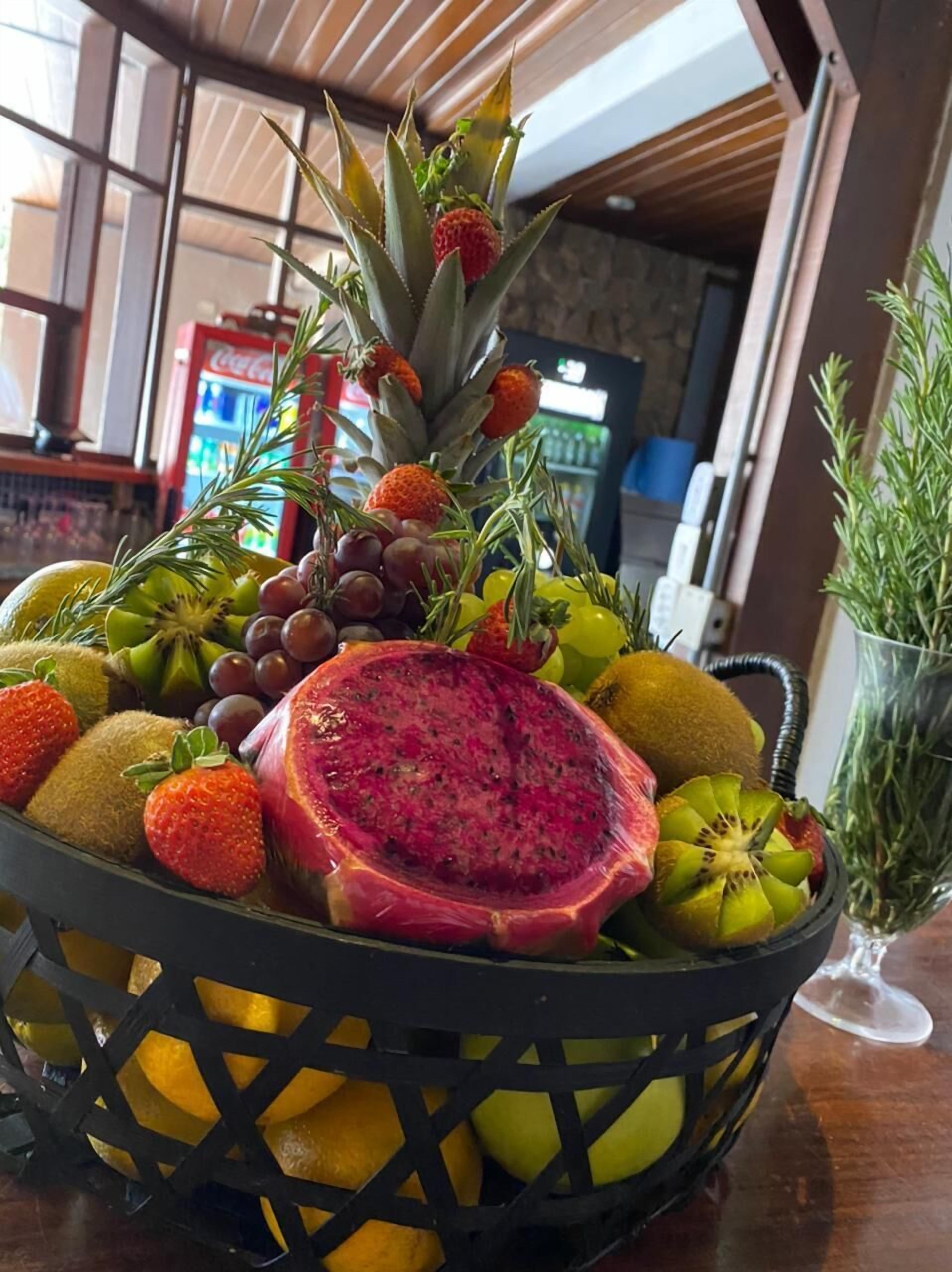 A fruit basket with various fruits including strawberries, grapes, kiwi, and dragon fruit.