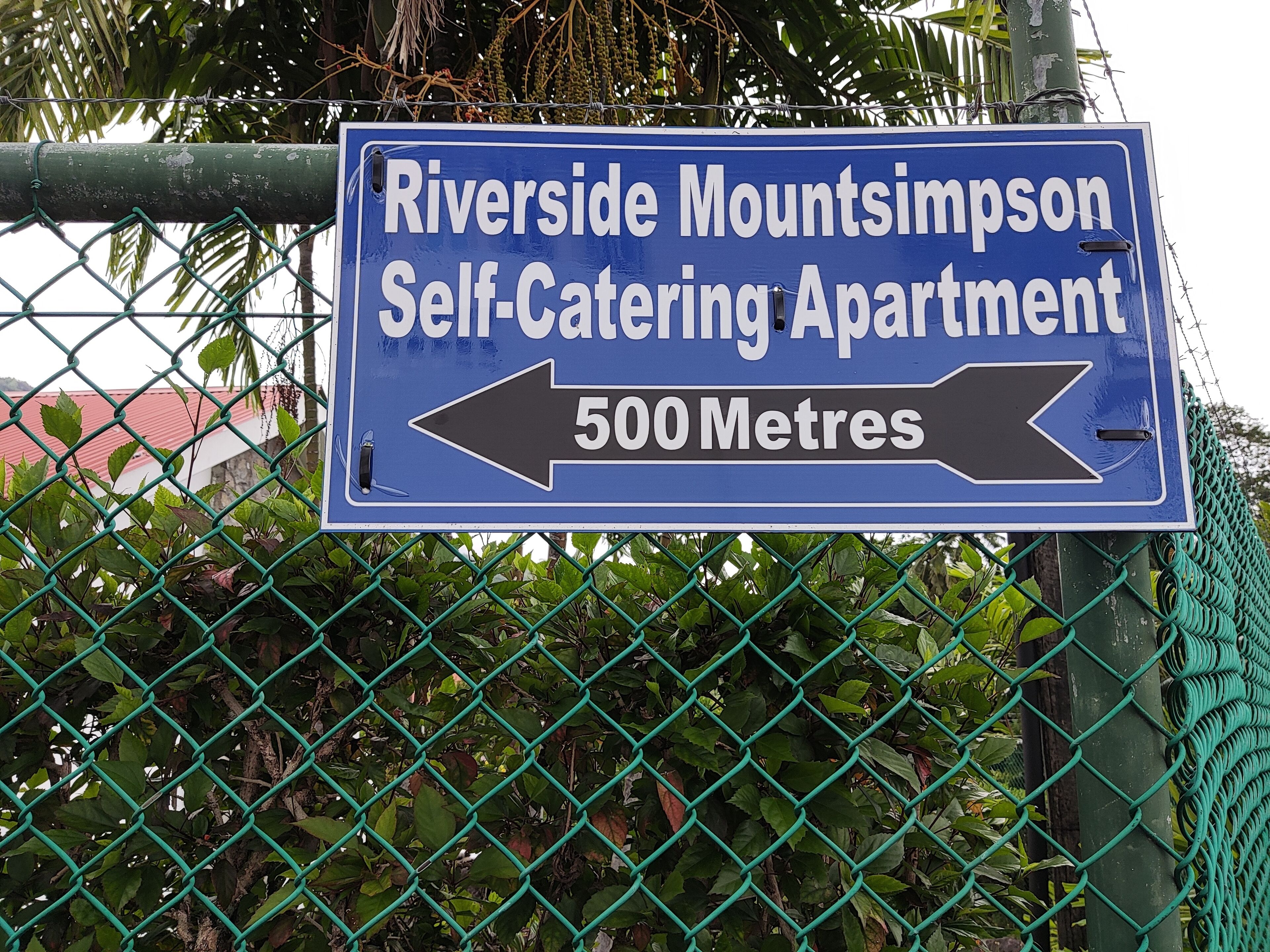 Un panneau indiquant l’emplacement de l’appartement Riverside Mountsimon, qui propose un hébergement en autonomie, et précisant qu’il se trouve à 500 mètres.