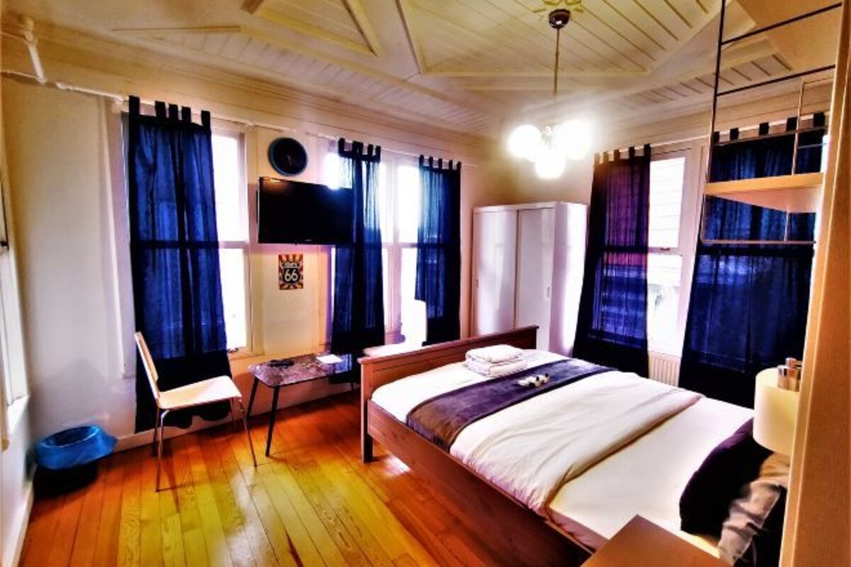 A room with a bed, a chair, a desk, and a wardrobe.