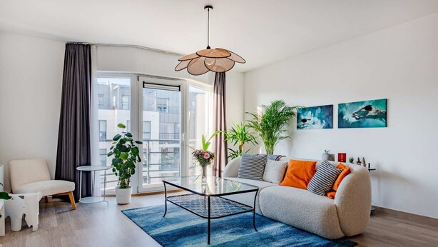 A modern living room with a sofa, coffee table, and a potted plant. - Brussels Royal Design Residence (Brussels)