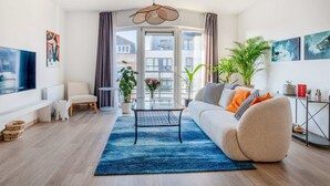 A modern living room with a sofa, coffee table, and potted plants. - Brussels Royal Design Residence (Brussels)