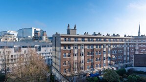 A multi-story building with a brick facade and large windows, surrounded by other buildings and trees. - Brussels Royal Design Residence (Brussels)