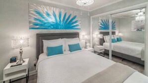 A modern bedroom with a large bed, a ceiling fan, and a large mirror. - Luxury Waterfront Condo with Heated Pool and Balcony (Tampa)