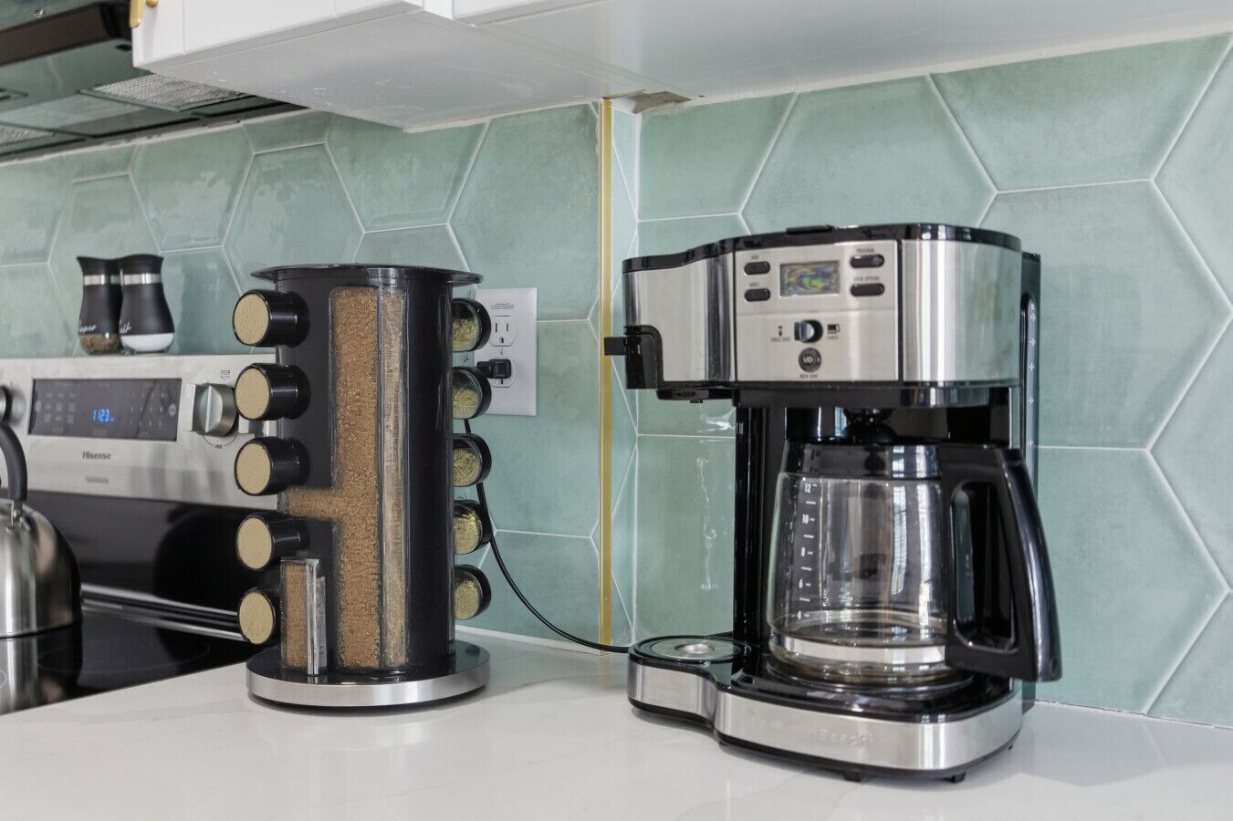 A kitchen with a coffee maker, a kettle, and a Hisense microwave.