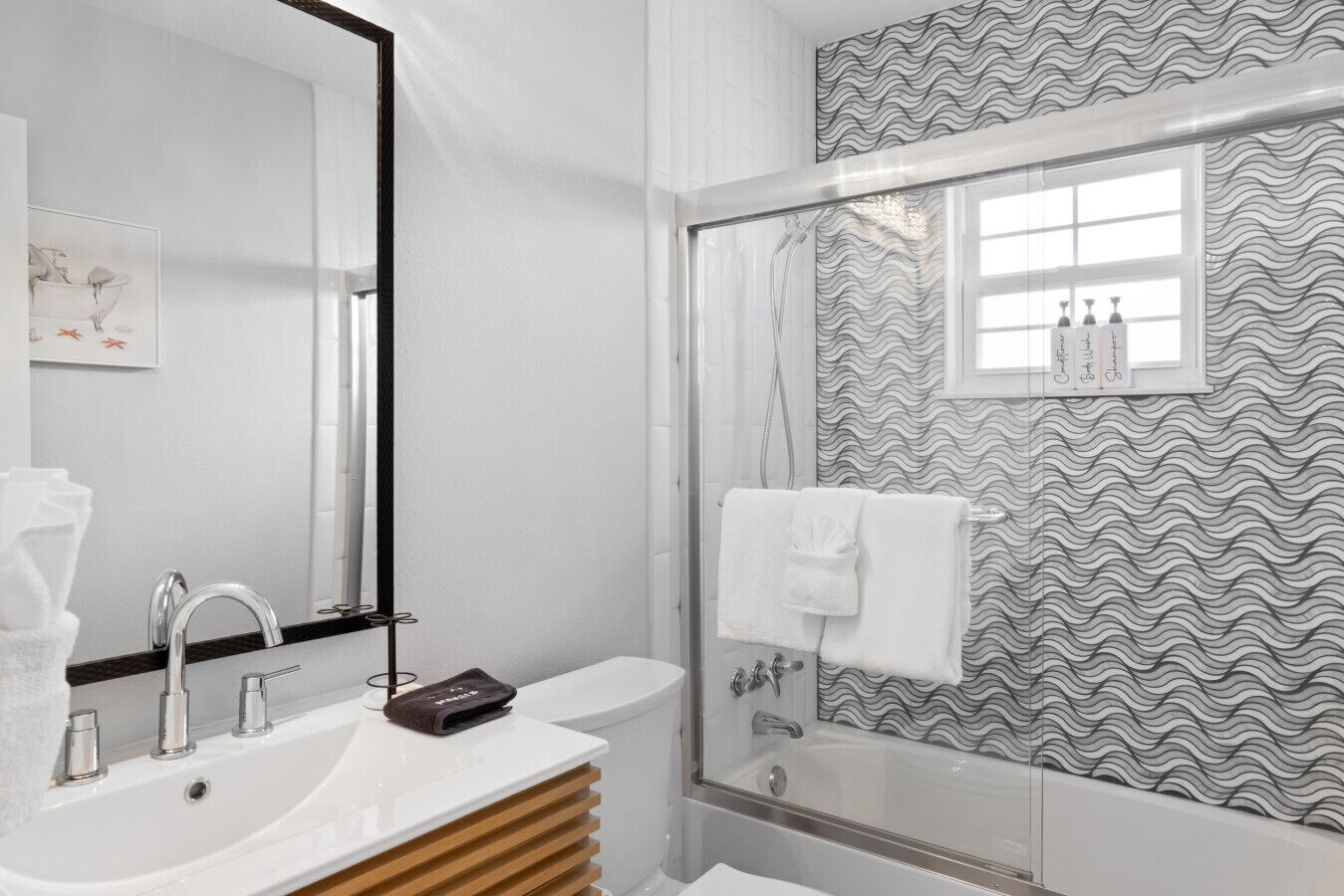Une salle de bain moderne avec un lavabo blanc, un miroir et un espace douche.