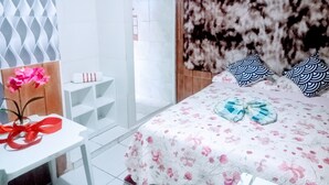 Un dormitorio con cama, mesita de noche, espejo y armario.