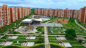 Un ensemble résidentiel comprenant plusieurs immeubles d’appartements en briques, une cour centrale avec un espace de jeux et des jardins aménagés.