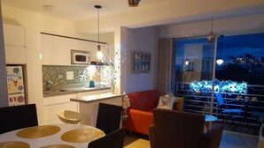 Une cuisine moderne équipée d’un four à micro-ondes, d’une table à manger avec des sets de table et d’un canapé rouge.