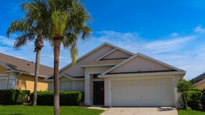 A single-story house with a garage, a driveway, and a palm tree in the front yard. - The Glenbrook Getaway – 4BR Resort Home with Pool & Spa (Four Corners)