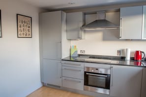 A modern kitchen with stainless steel appliances, a built-in oven, and a coffee maker.