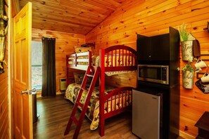 A cabin with a bunk bed, a refrigerator, a microwave, and a small kitchenette. - Bigfoot Lodge Room Three - Outdoor Adventures (Benton)