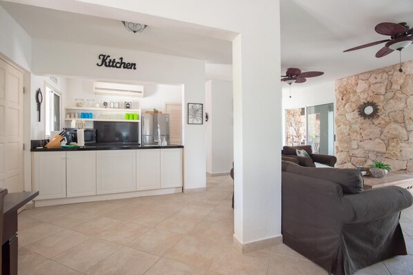 A modern kitchen with white cabinets, a black countertop, and a ceiling fan. - Casa Karlina - Three Bedroom Villa, Sleeps 6 (Noord)