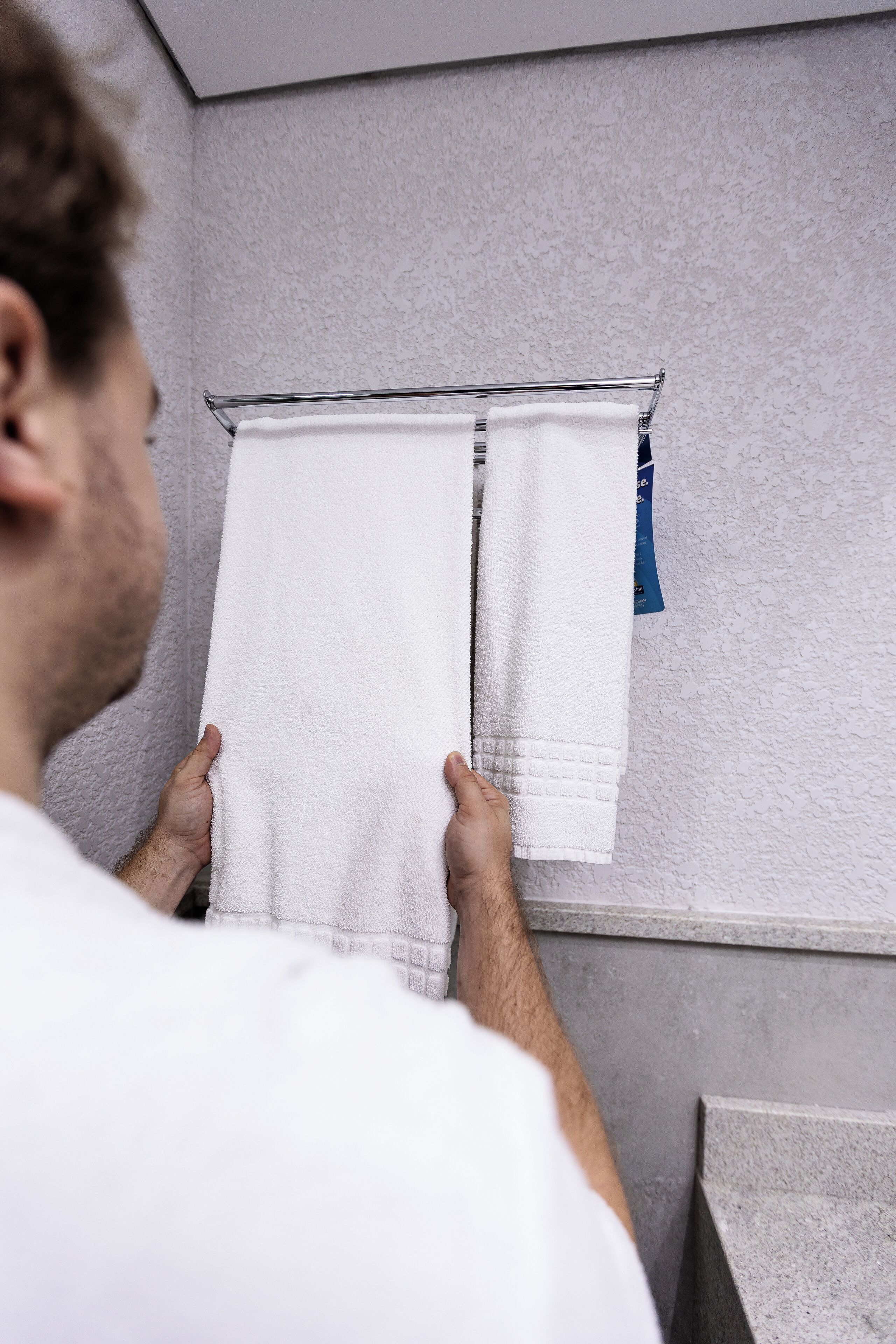 A bathroom with a towel rack holding two white towels.