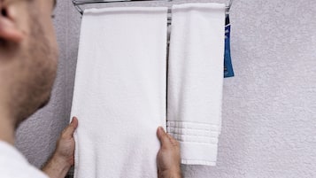 A bathroom with a towel rack holding two white towels.