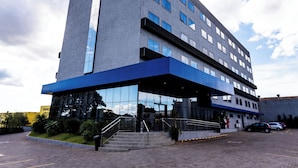 A modern hotel with a flat facade, large windows, and a blue overhang. - Days Inn By Wyndham Cascavel (Cascavel)