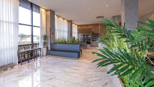 A spacious lobby with a marble floor, seating area, large windows, and indoor plants. - Days Inn By Wyndham Cascavel (Cascavel)