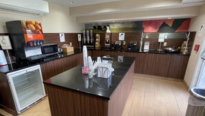 A modern kitchen with a central island, a refrigerator, and a microwave. - Baymont By Wyndham Dayton North (Dayton)