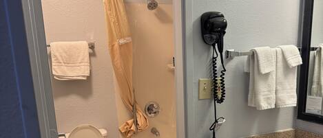 A bathroom with a toilet, bathtub, and a sink with a mirror.