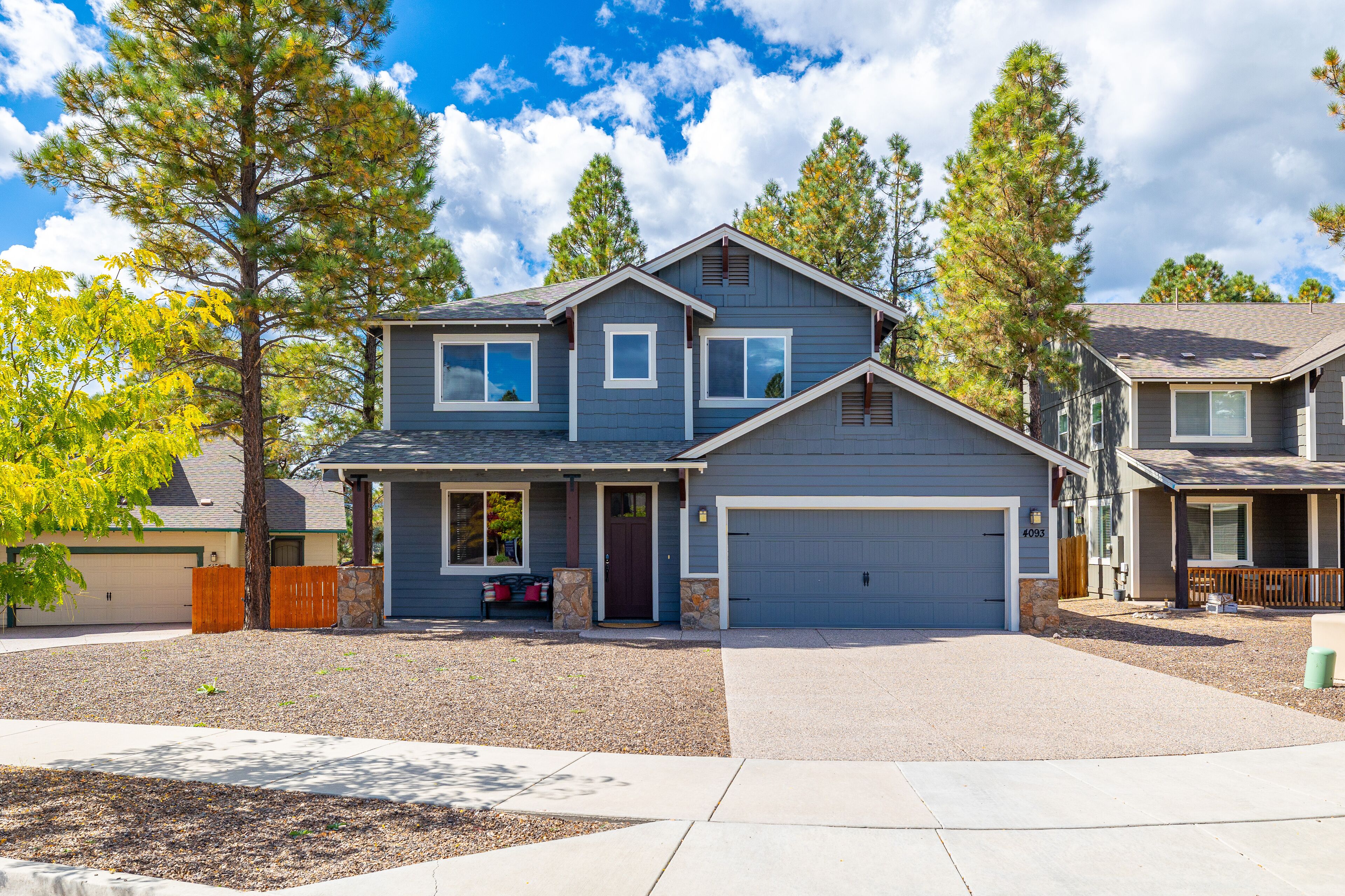 A two-story house with a garage, a front porch, and a driveway.