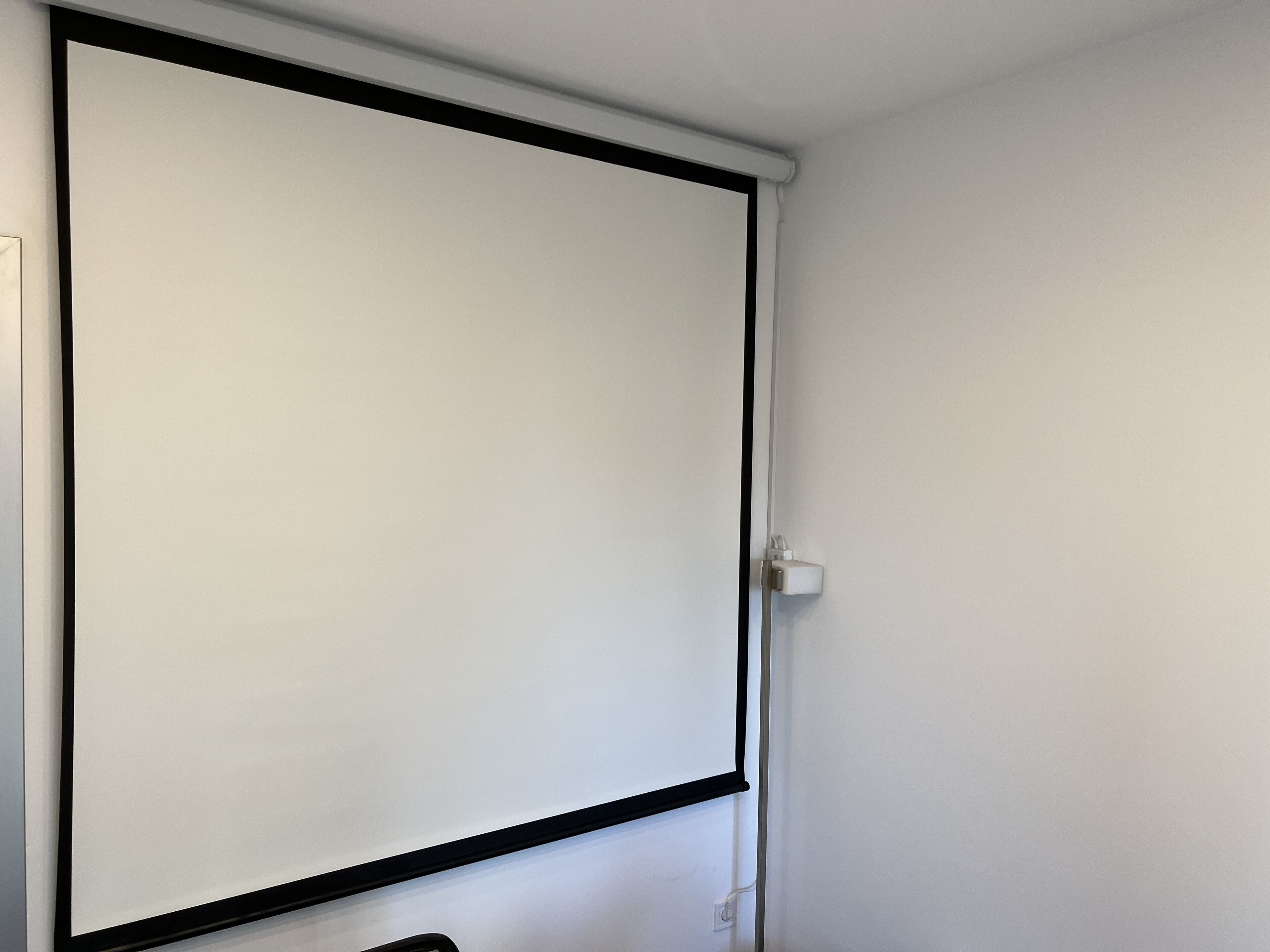 A closed door with a black frame and a white wall.