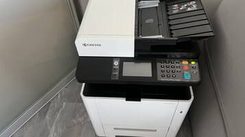 A Kyocera multifunction printer with a control panel, a paper tray, and a document feeder.
