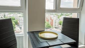 A room with a table and two chairs, a window with a view of buildings, and a tray on the table. - Cozy Penthousestudio Cityview W12 (Bucharest)