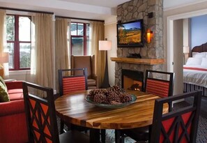 Relax in a serene space with a round dining table, fireplace, and comfortable bed.